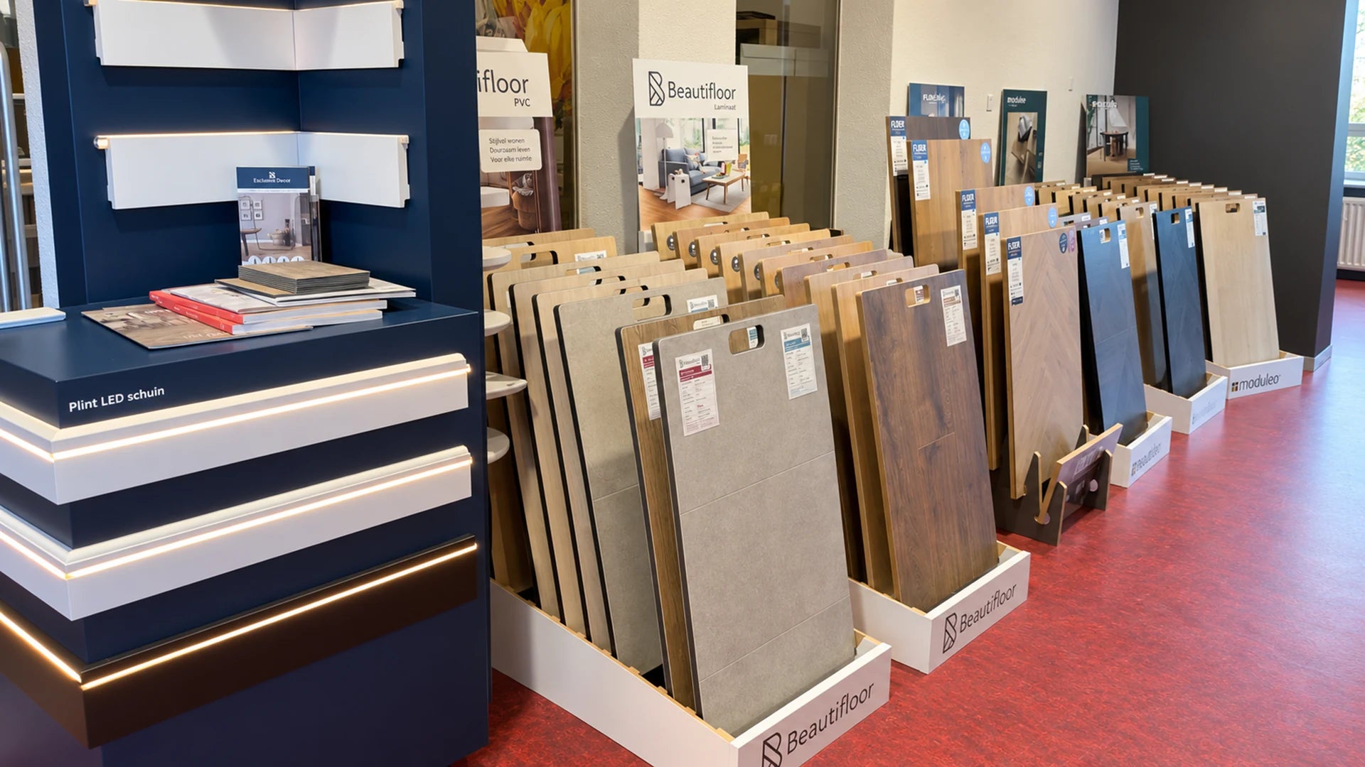 Gang langs vloercollecties en profielpresentaties in de showroom